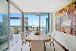 a dining room with a table and views of the ocean at Lookout 334 - Endless Ocean Views - Rooftop Spa in Kingscliff