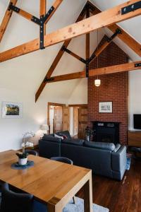 een woonkamer met een bank en een tafel bij Homestead Loft- Private retreat, amongst the gums with woodfire and spa bath in Wallington