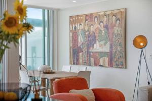 a dining room with a table and a painting on the wall at Lookout 334 - Endless Ocean Views - Rooftop Spa in Kingscliff +43 photos