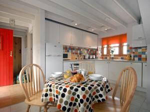 a kitchen with a table with a polka dot table cloth at Rias Cottage in Landshipping