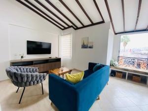 uma sala de estar com um sofá azul e uma televisão em Hermoso apartamento en Envigado em Envigado