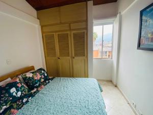 um quarto com uma cama e uma grande janela em Hermoso apartamento en Envigado em Envigado