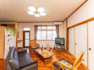 Ie的住宿－AGARI 伊江島 Ie Island，客厅配有沙发、椅子和桌子