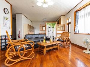 AGARI 伊江島 Ie Island في Ie: غرفة معيشة مع أريكة وطاولة وكراسي