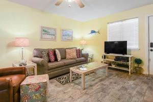 a living room with a couch and a tv at Kimberly Villa in Panama City Beach