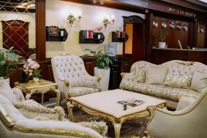 een woonkamer met witte meubels en een tafel en stoelen bij ROYAL RESIDENCE in Tasjkent