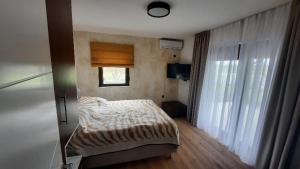 una piccola camera da letto con un letto e una finestra di Boletov raj lux a Čurug