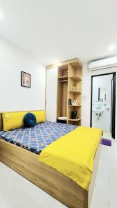 een slaapkamer met een bed met een gele deken bij Hanoi Cozy Homestay Long Biên in Hanoi