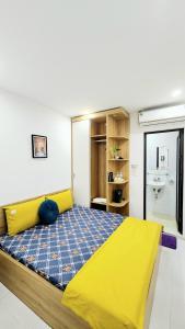 1 dormitorio con cama amarilla y lavamanos en Hanoi Cozy Homestay Long Biên, en Hanói