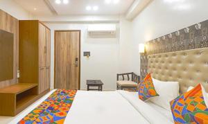 a hotel room with a bed and a desk and a room at FabHotel Palash in Dānāpur