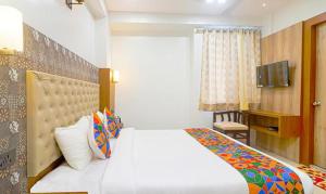 a hotel room with a bed and a television at FabHotel Palash in Dānāpur