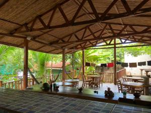 a pavilion with tables and chairs on a patio at El Marabu Chill'n Surf in Aposentillo