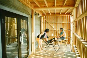 two men sitting on chairs in a room at MUSIRO STAY and SAUNA in Yokote