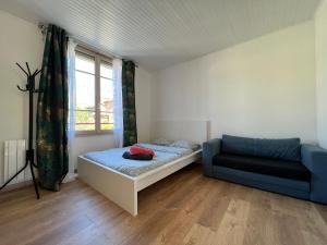 een slaapkamer met een bed, een bank en een raam bij Charmant logement centre ville Rosny Sous Bois in Rosny-sous-Bois