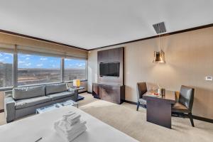 a living room with a couch a table and a tv at VDARA HOTEL Premium Studio Suite * FREE VALET PARKING in Las Vegas
