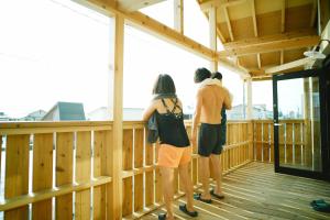 a group of three people standing on a wooden deck at MUSIRO STAY and SAUNA 