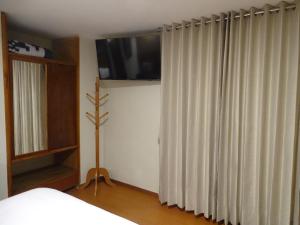 a bedroom with a bed and a window with curtains at Artezana Hotel in Cusco +23 photos