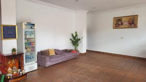 a living room with a purple couch in a room at PHAPPY GUEST HOUSe in Phnom Penh