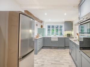 cocina con armarios grises y nevera de acero inoxidable en Misdale House en Louth