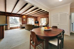 a living room with a wooden table and chairs at Muller's Cottage at Hat Head (Pet Friendly) in Hat Head