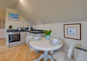 a kitchen with a white table and chairs at The Barn Studio in Benenden