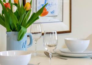 a table with two wine glasses and a vase of flowers at The Barn Studio in Benenden