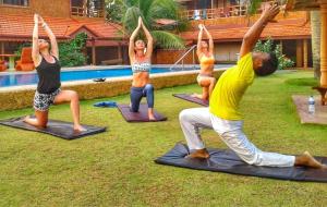 a group of people doing yoga by a pool at Alai Resort in Mullaittivu