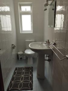 bagno con lavandino, servizi igienici e finestra di Perfect tourist accommodation in Bugibba square! a San Pawl il-Baħar