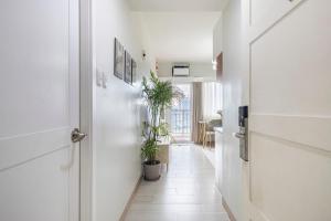a hallway with potted plants and a white door at Make Yourself Feel at Home in 2BR I Free Parking in Manila