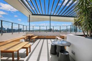 - un balcon avec des tables et des bancs en bois dans un bâtiment dans l'établissement 'Easy Jeays' Executive Living near Fortitude Valley, à Brisbane