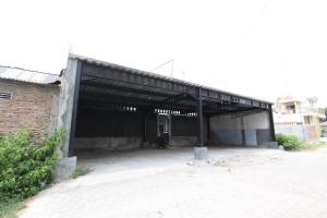 uma grande garagem de metal com um edifício de tijolos em SPOT ON 93245 Guet House Mulia Dua Syariah em Klaten