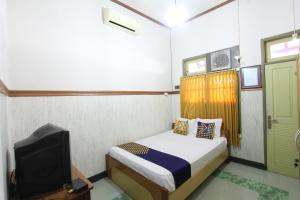 a small bedroom with a bed and a tv at OYO Life 93247 Pondok Pariwisata in Mataram