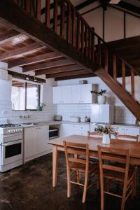 Forest Grove的住宿－Cottage 1 - The Row，厨房配有木桌、椅子和木制楼梯。
