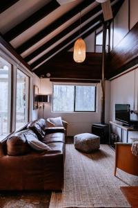 Forest Grove的住宿－Cottage 1 - The Row，客厅配有真皮沙发和电视