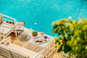 eine Terrasse mit einem Tisch und Stühlen neben einem Pool in der Unterkunft Ev Bharat Butique Hotel, Alaçatı in Alacati