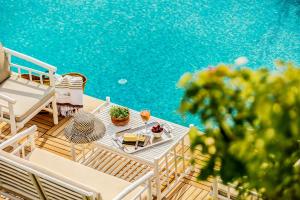 Eine Terrasse mit Tisch und Stühlen neben einem Pool in der Unterkunft Ev Bharat Butique Hotel, Alaçatı in Alacati