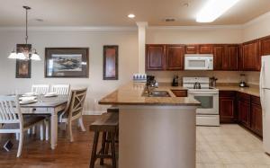 a kitchen with wooden cabinets and a table with a sink at 8000TW Unit 4403- Tuscana Resort in Kissimmee