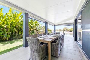 uma sala de jantar exterior com mesa e cadeiras em YALLA24-Luxury Resort Style Home em Mooloolaba