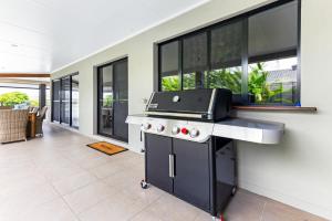 a kitchen with a grill on a counter with windows at YALLA24-Luxury Resort Style Home in Mooloolaba