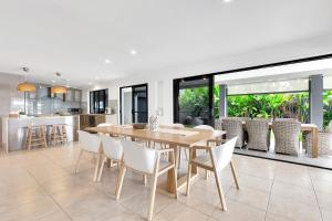 a dining room and kitchen with a table and chairs at YALLA24-Luxury Resort Style Home in Mooloolaba