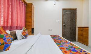 a bedroom with a bed with a colorful blanket on it at FabHotel Royal Palace in Indore