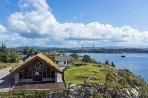 ein Haus auf einem Hügel neben einem Wasserkörper in der Unterkunft beautiful villa with seaview and sunny in Askøy