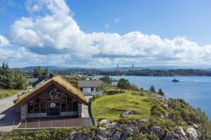 a house on a hill next to a body of water at beautiful villa with seaview and sunny in Askøy