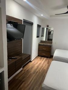 a room with two beds and a flat screen tv at Hotel don Bosco in Guadalajara
