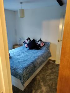 1 dormitorio con 1 cama con edredón azul en Phoenix cottage, 