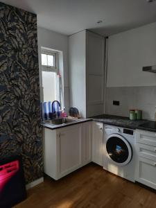 a kitchen with a sink and a washing machine at Phoenix cottage 