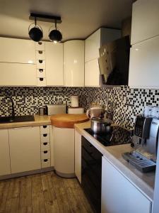 uma cozinha com armários brancos e azulejos pretos e brancos em Bieszczadzka Sielanka em Wojtkowa