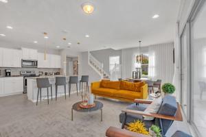 ein Wohnzimmer und eine Küche mit einem gelben Sofa in der Unterkunft Cozy Neverland Retreat for a Whimsical Getaway in Kissimmee