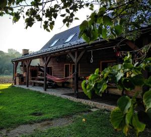 ein Haus mit Solardach und einer Hängematte im Außenbereich in der Unterkunft Bieszczadzka Sielanka in Wojtkowa