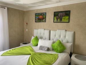 sypialnia z dużym łóżkiem z zielonymi poduszkami w obiekcie Nonesi Lodge 2 w mieście Queenstown